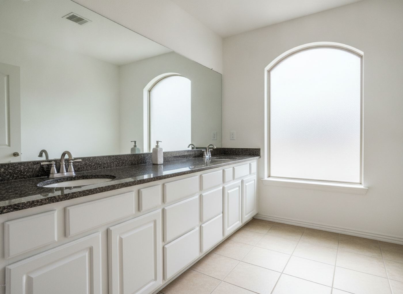 Double bathroom vanity with white painted raised-panel doors and a granite top in a Dallas-area home