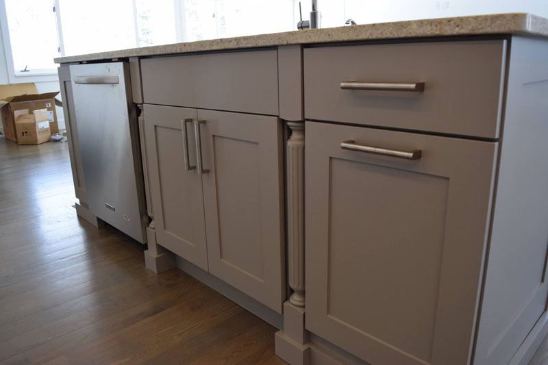 Island cabinets painted light gray with long bar pulls