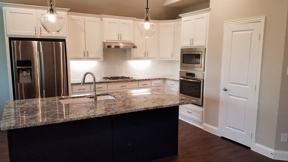 White painted perimeter cabinets with a dark painted island