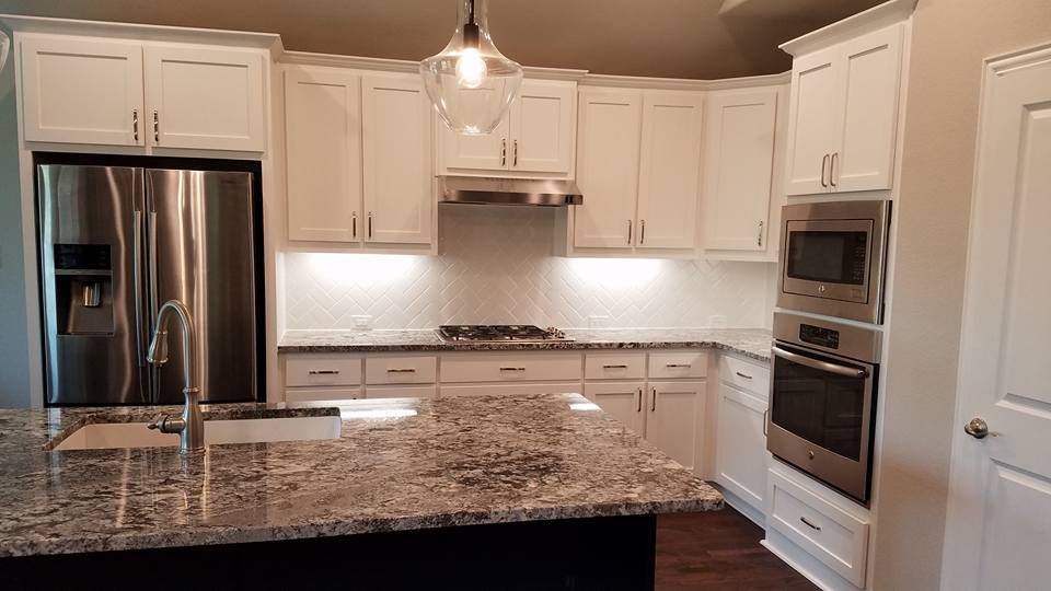 White painted kitchen with a quartz island and stainless appliances