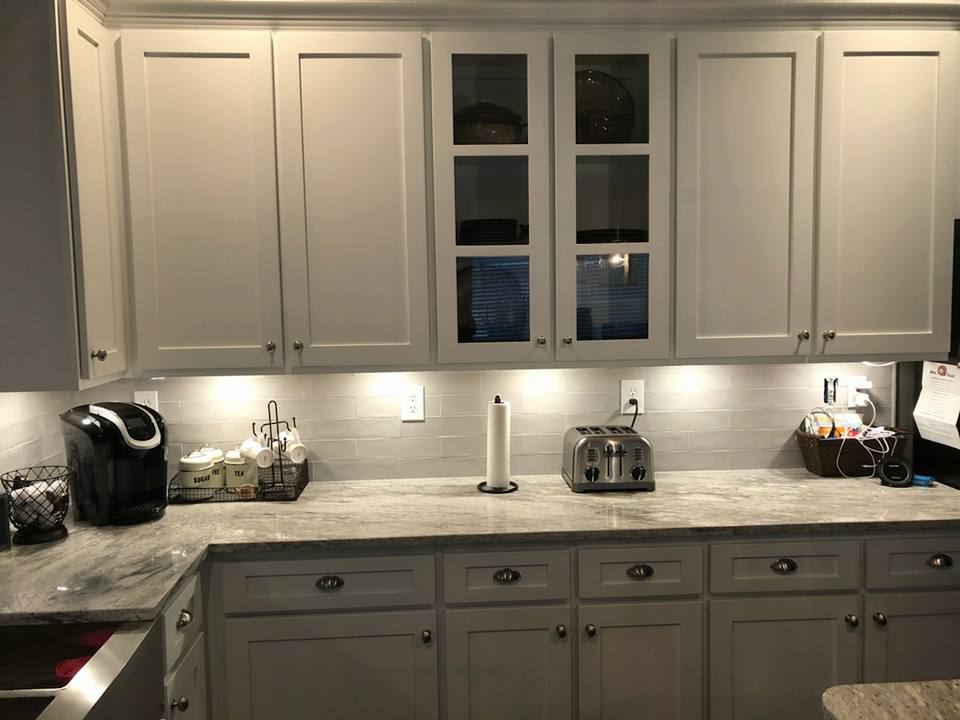 Two-tone cabinets: white uppers, gray painted lowers, under-cabinet lights