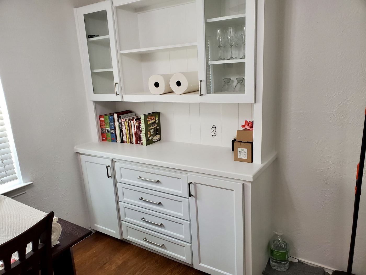 White built-in hutch with glass doors, open shelves and drawers