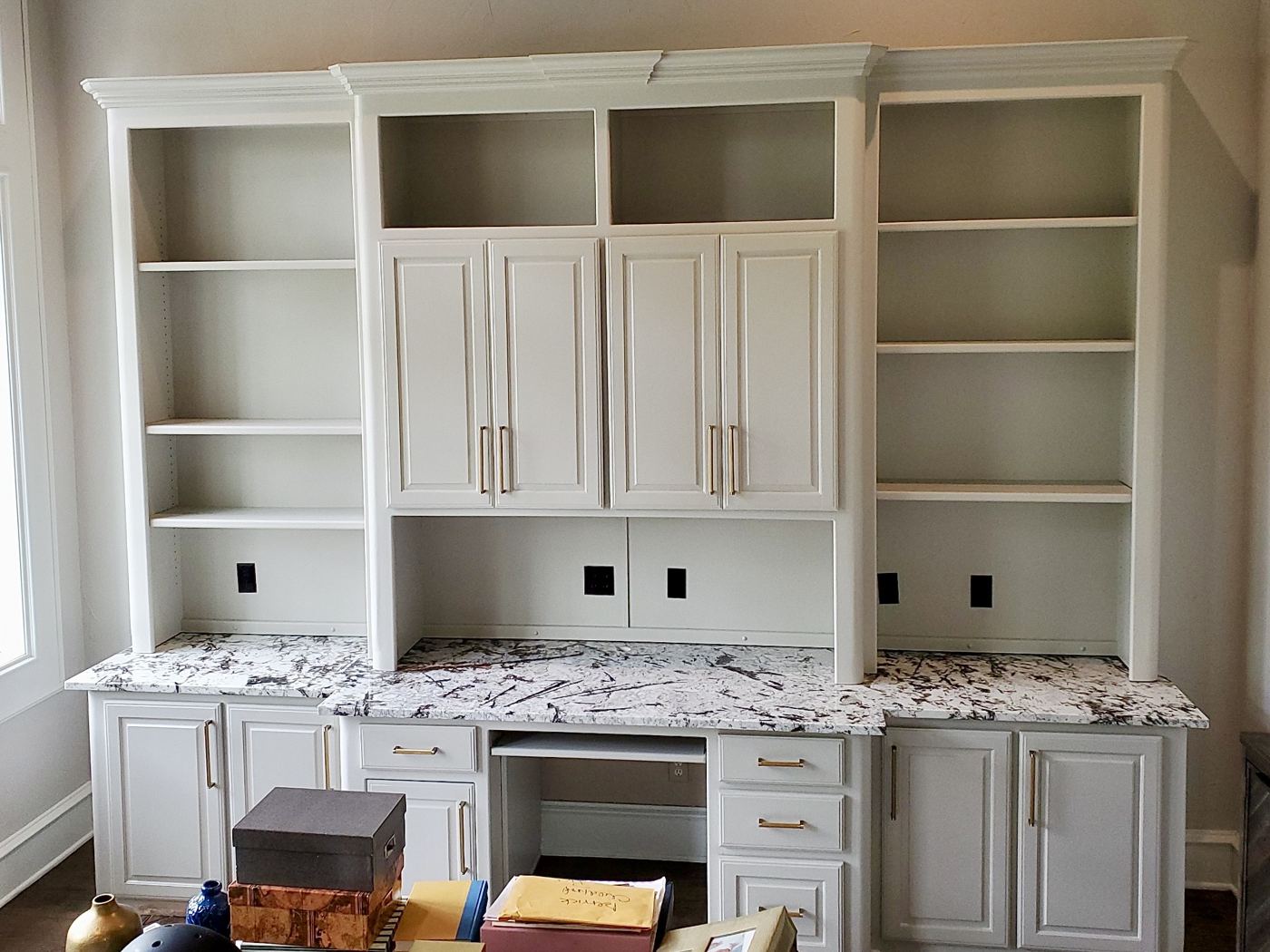 White built-in wall unit with a desk, cabinets and open shelves