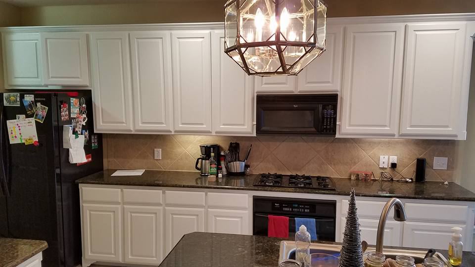 The same kitchen after the cabinets were painted white, same granite and lantern